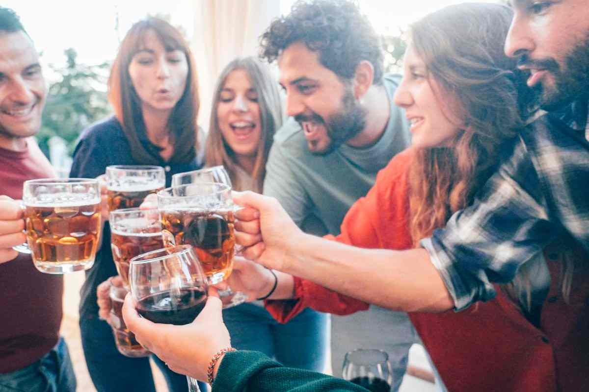 ragazzi che brindano con birra e vino