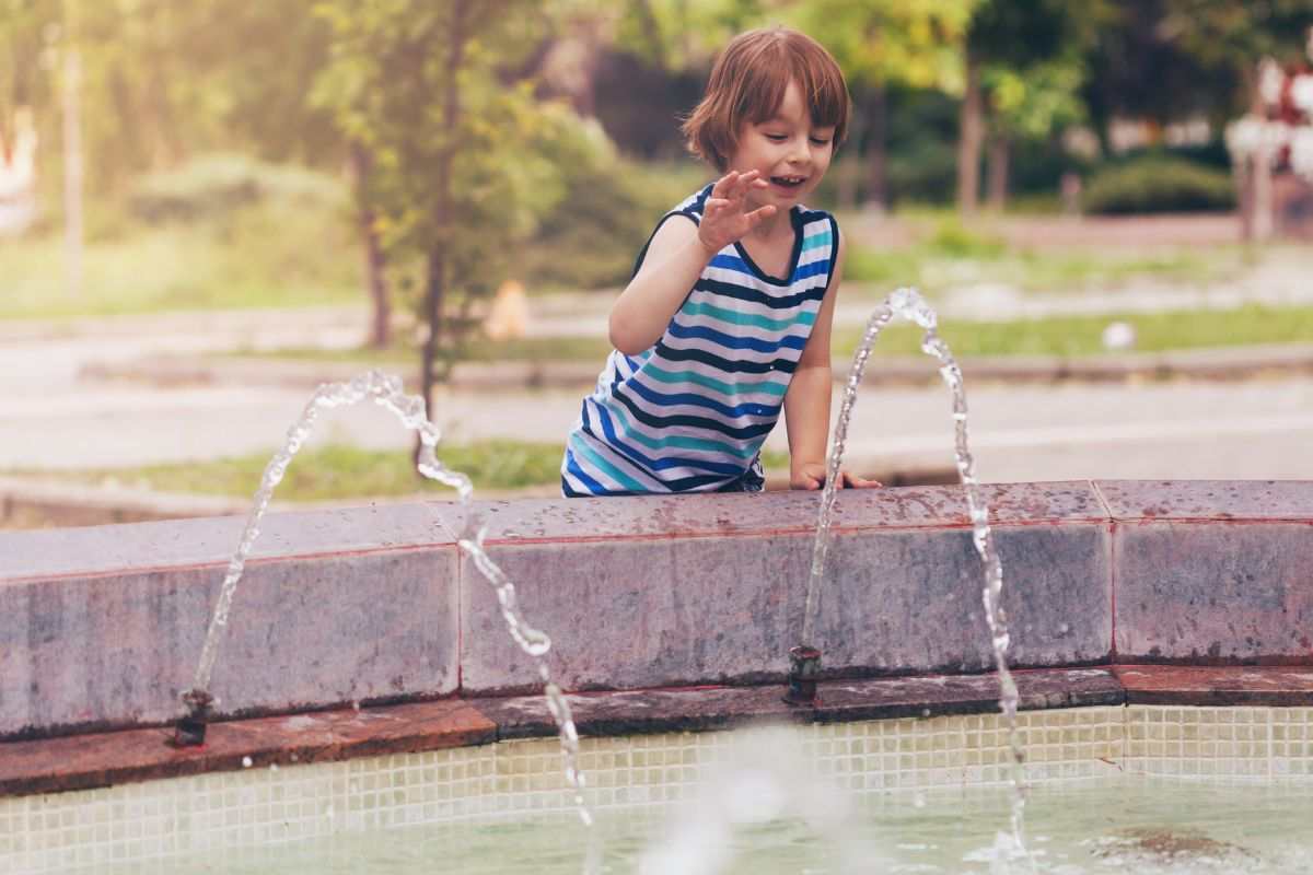Bambini che si rinfresca alla fontana