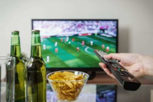guardare sport, patatine, birra e telecomando